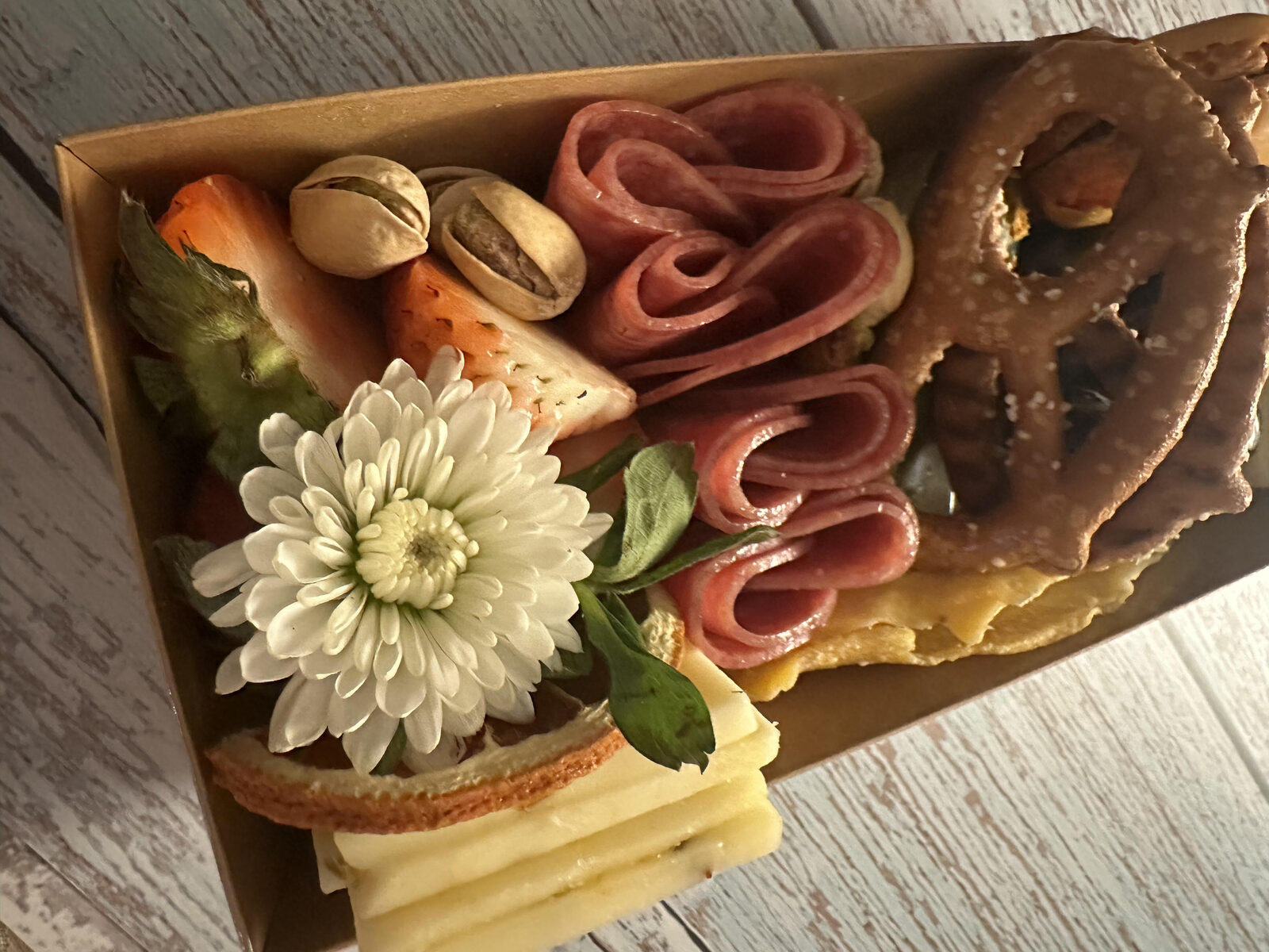 Personal box with salami, pretzel, cheese, and a flower